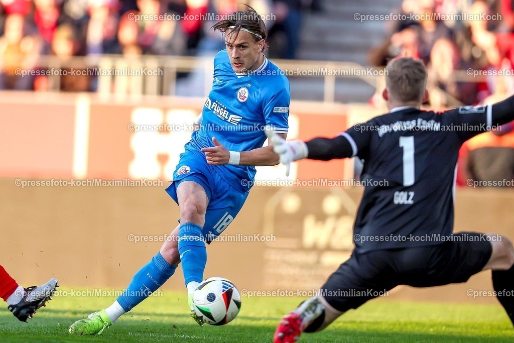 RWE06042501023 | 2025.04.06, Fußball, 3.Liga, Rot-Weiss Essen - FC Hansa Rostock, Stadion Hafenstraße, Saison 2024 2025: Sigurd Haugen (FC Hansa Rostock #18) Schuss auf das Tor von Torwart Jakob Golz (RWE #1) DFB regulations prohibit any use of photographs as image sequences and or quasi-video.