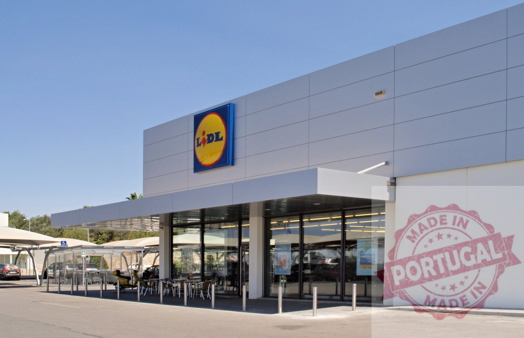 Lidl grocery store exterior on a clear day | Lidl supermarket exterior with logo, entrance, and car parking on a sunny day - Realisiert mit Pictrs.com
