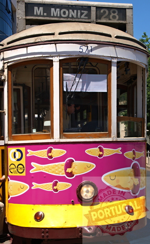 Colorful Lisbon Tram Number 28 Showing Sardines Advertising Campaign | Yellow and pink Lisbon tram number 28 showing sardines advertising campaign, parked on a sunny day - Realized with Pictrs.com