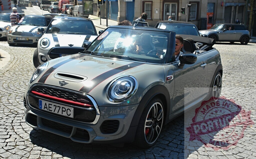 Grey Mini John Cooper Works Convertible leading a parade of Minis | Grey Mini convertible leading a group of Minis during a sunny day parade - Realized with Pictrs.com