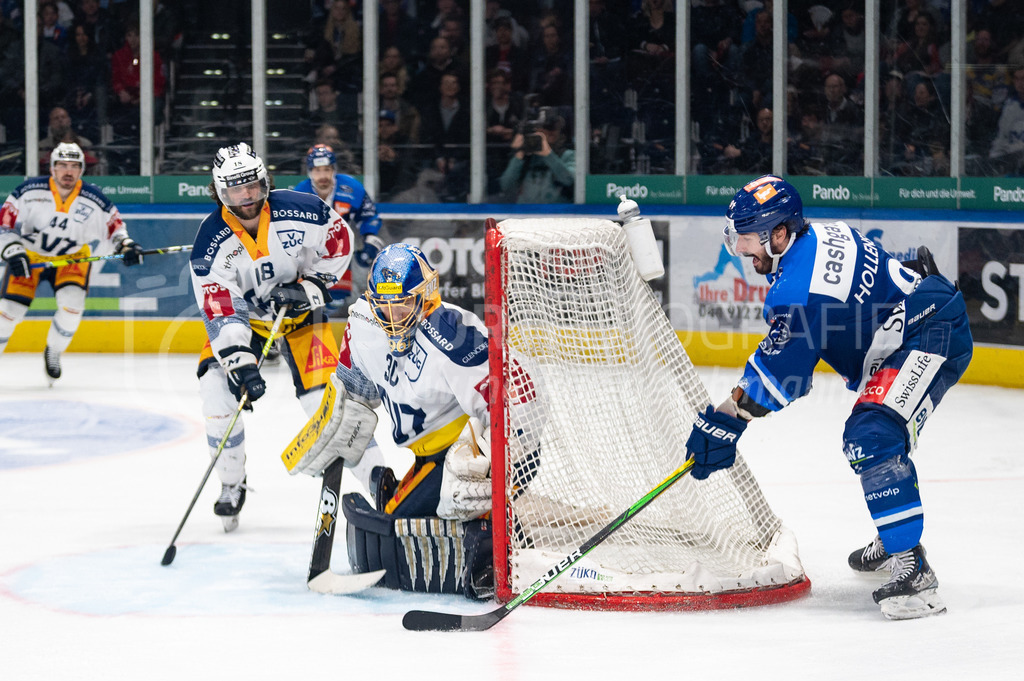 Swiss National League Final Game 2: ZSC Lions - EV Zug | 20.04.2022, Zürich, Hallenstadion, Swiss National League Final Game 2: ZSC Lions - EV Zug, #91 Denis Hollenstein (ZSC) versucht es mit dem „Buebetrickli“, #30 Torhüter Leonardo Genoni (Zug) ist jedoch zur Stelle, hinten ist #18 Dominik Schlumpf (Zug) bereit. - Realisiert mit Pictrs.com