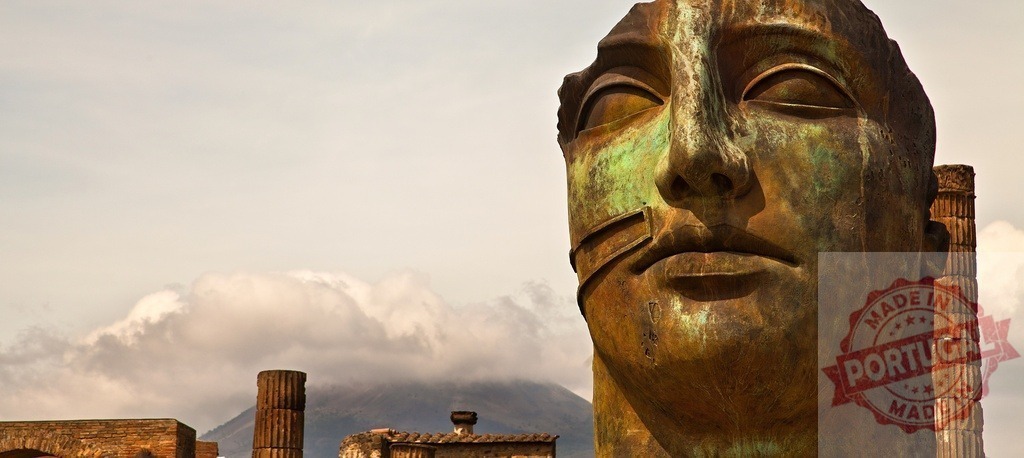 Igor Mitoraj sculpture at Pompeii with Mount Vesuvius | Mitoraj's bronze sculpture featuring a fractured face in ancient Pompeii with Mount Vesuvius - Realized with Pictrs.com