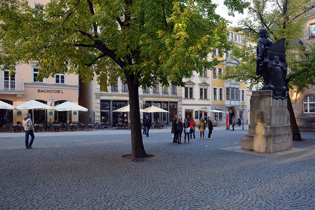 Bildlexikon Leipzig - Thomaskirchhof mit Bach Denkmal | Das Team hinter BILDLEXIKON LEIPZIG bündelt historische wie aktuelle Informationen über die Stadt Leipzig in Text und Bild auf einer Plattform und stellt diese der interessierten Öffentlichkeit zur Verfügung.