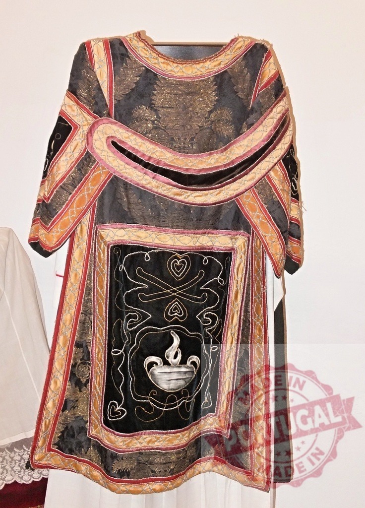 Decorative liturgical vestment hanging, showcasing intricate embroidery and religious symbolism | Liturgical vestment with intricate embroidery, gold and velvet details, and religious symbols, hanging against a white background - Realized with Pictrs.com