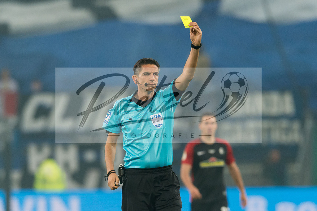 HSVSCF20220419_364 | Fussball, Herren: Referee Deniz Aytekin zeigt die gelbe Karte beim DFB-Pokal-Halbfinalspiel zwischen Hamburger SV und SC Freiburg im Volksparkstadion am 19.04.2022 in Hamburg, Deutschland.DFB / DFL REGULATIONS PROHIBIT ANY USE OF PHOTOGRAPHS AS IMAGE SEQUENCES AND/OR QUASI-VIDEO. - Realisiert mit Pictrs.com