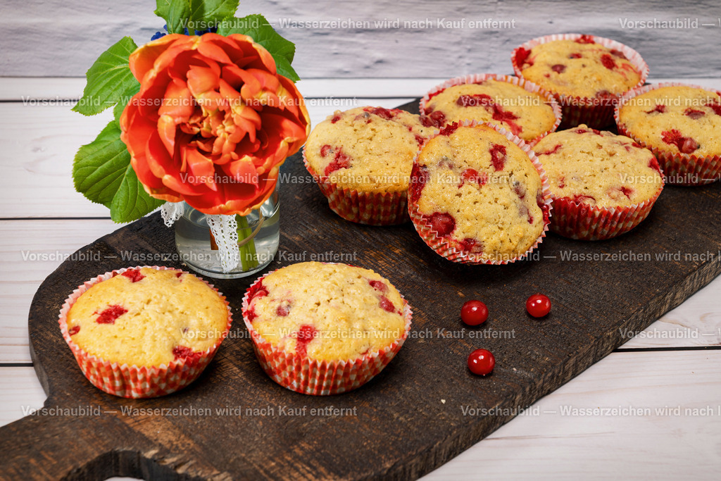 Muffins mit roten Johannisbeeren | Muffins mit roten Johannisbeeren, angerichtet auf einem rustikalen Holzbrett. - Realisiert mit Pictrs.com