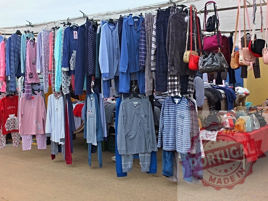 Pajamas and bags for sale at street market stall | Pajamas and handbags displayed for sale at an outdoor stall, symbolizing retail shopping and commerce - Realisiert mit Pictrs.com