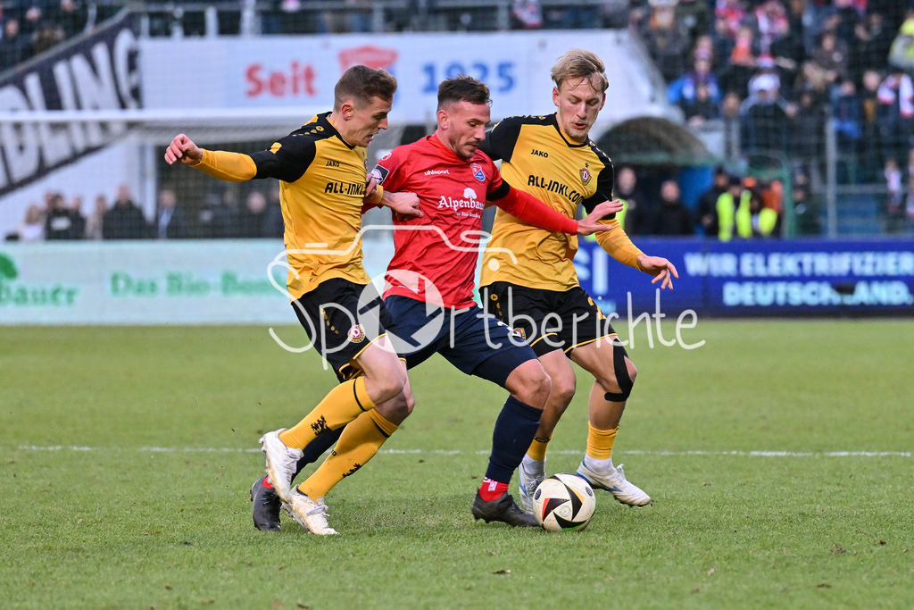 SpVgg Unterhaching - Dynamo Dresden | v. l. Niklas HAUPTMANN (Dynamo Dresden 27) / Simon SKARLATIDIS (UHG #30) und Sascha RISCH (Dynamo Dresden 28) / Zweikampf / 3. Liga: SpVgg Unterhaching - Dynamo Dresden, Uhlsportpark am 21.12.2024