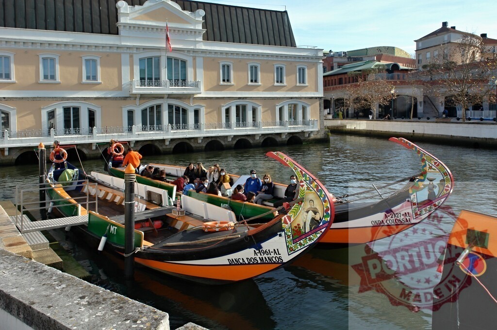 Traditional moliceiro boats navigating canal in Aveiro, Portugal | Tourists enjoying a relaxing moliceiro boat ride along a canal in Aveiro - Realized with Pictrs.com