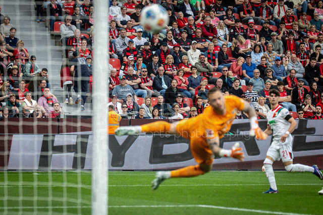 German Bundesliga, Bayer 04 Leverkusen vs. FC Augsburg, 18.04.2026 | LEVERKUSEN, GERMANY - APRIL 18, 2026 :  Spectators viewing  Keeper Mark Flekken (Bayer 04 Leverkusen, 1) flying after the ball during the German Bundesliga match on gameday 30 between Bayer 04 Leverkusen vs. FC Augsburg at BayArena on April 18, 2026 in Leverkusen, Germany. DFL REGULATIONS PROHIBIT ANY USE OF PHOTOGRAPHS AS IMAGE SEQUENCES AND/OR QUASI-VIDEO.