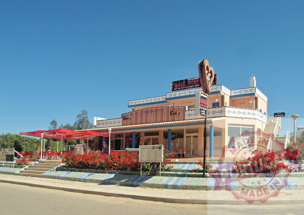 Gale Piri Piri restaurant in Algarve, Portugal with red flowers | Gale Piri Piri restaurant building with sunny outdoor terrace and blooming red flowers under a clear blue sky - Realisiert mit Pictrs.com