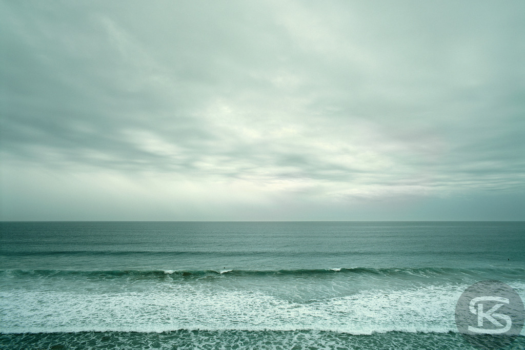 Stimmungsvolle Atlantikküste am Jalama Beach, Westküste USA | Eine atmosphärische Aufnahme der rauen Schönheit des Jalama Beach in Kalifornien. Das Bild fängt die typischen windigen Bedingungen und die dynamischen Wellen der Westküste ein, mit einem weiten Horizont unter einem bedeckten, grau-grünen Himmel. Es vermittelt ein Gefühl von Abgeschiedenheit und unberührter Natur. - Realisiert mit Pictrs.com