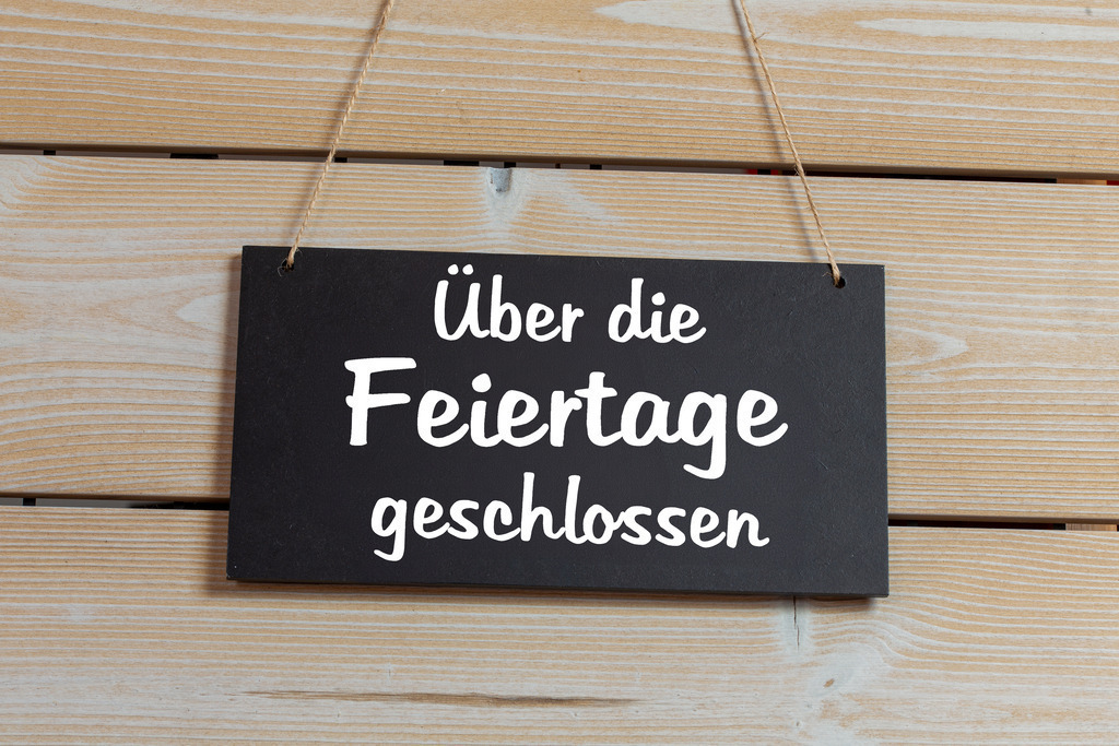 Symbolbild Betriebsferien: Schild an einer Holztafel mit der Aufschrift ÜBER DIE FEIERTAGE GESCHLOSSEN | Symbolbild Betriebsferien: Schild an einer Holztafel mit der Aufschrift ÜBER DIE FEIERTAGE GESCHLOSSEN - Realisiert mit Pictrs.com