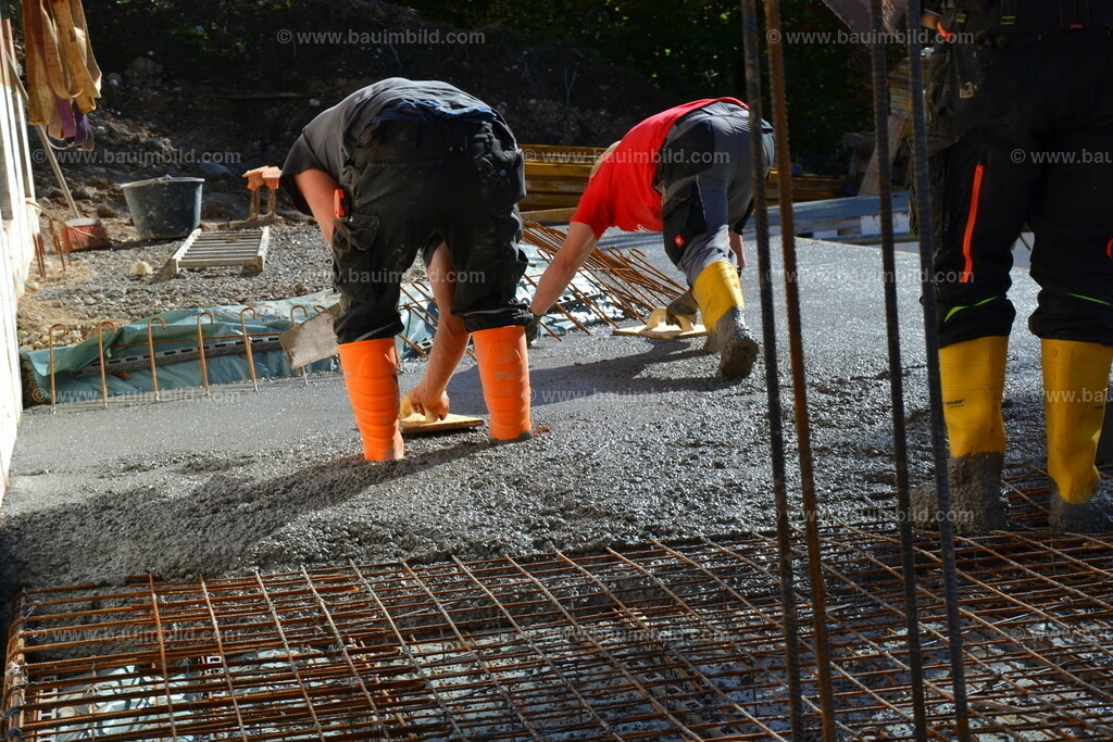Betonbearbeitung | Arbeiter mit Reibebrettern beim Glätten von Beton