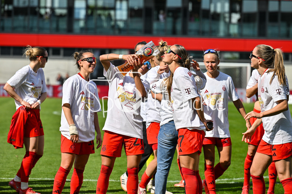 FC Bayern München - SC Freiburg | Die Spielerinnen des FC Bayern feiern die Meisterschaft nach dem Heimsieg gegen den SC Freiburg / Frauen Bundesliga: FC Bayern Muenchen - SC Freiburg, FC Bayern Campus am 27.04.2025 / Arianna CARUSO (FC Bayern Muenchen Frauen 27) gibt Klara BUEHL (FCB #17) einen Schluck auf dem Paulaner Bierkrug / Bierglas