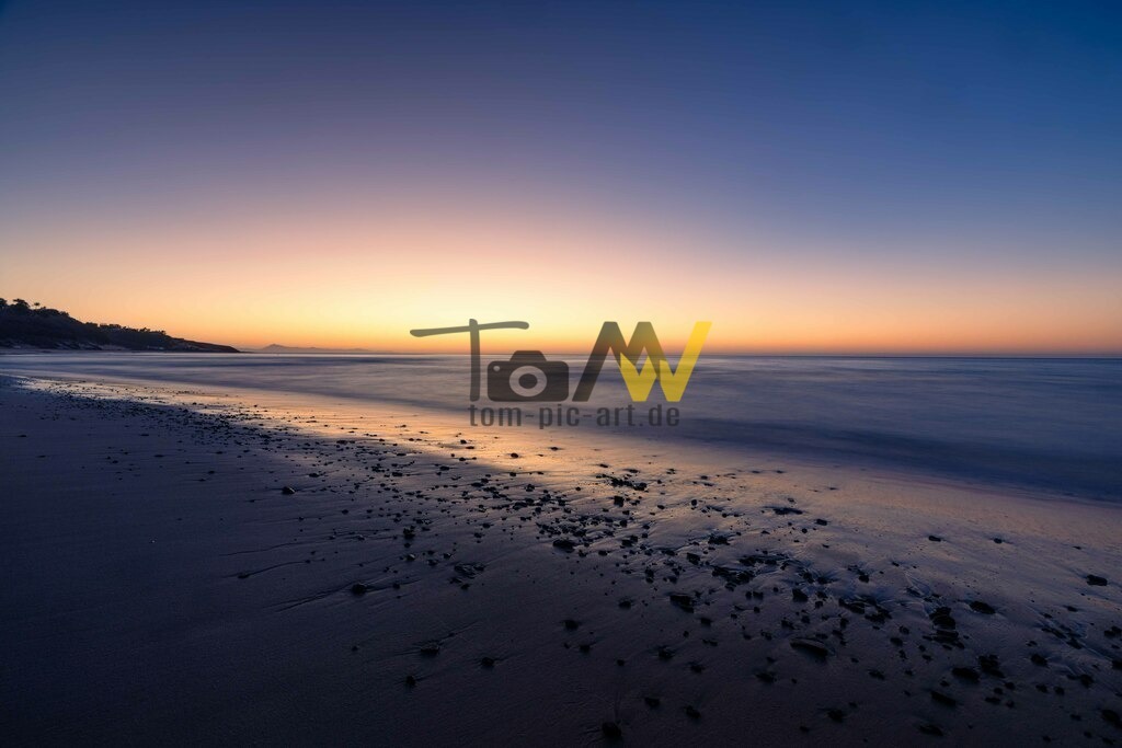 Der Tag bricht an-Sonnenaufgang am Strand auf Fuerteventura | Noch bevor die Sonne zu sehen ist, zeichnet sich ab, daß bald ein schöner Sonnenaufgang hereinbricht. Eine wunderbare Mischung aus orange blau und violett Farbtönen. - Realisiert mit Pictrs.com