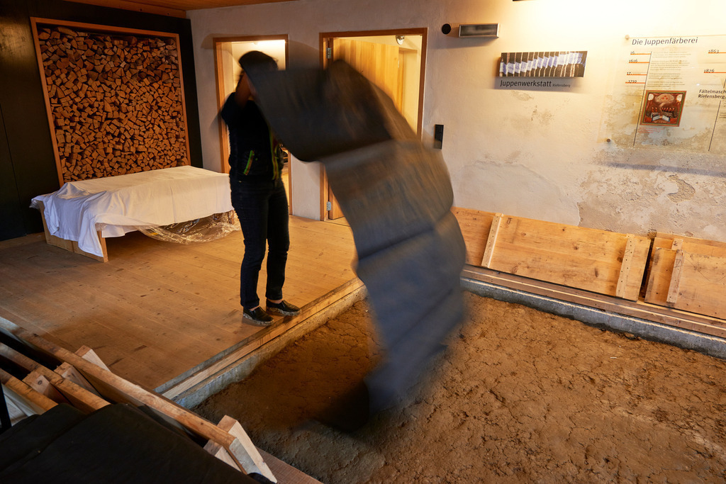 Der befeuchtete Stoff wird gewendet | Riefensberg, Austria - September 14, 2017: Juppenwerkstatt Riefensberg; Der befeuchtete Stoff wird von Frau Mike Steurer gewendet. - Realisiert mit Pictrs.com