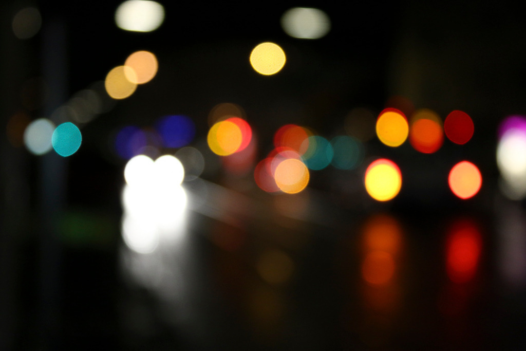 City Lights – Farbenspiel bei Nacht | Verschwommene Stadtlichter bei Nacht in kräftigen Farben. Das abstrakte Bokeh-Motiv eignet sich gut als modernes Wandbild für Büros, Praxen oder Wohnräume mit urbanem Stil. - Realisiert mit Pictrs.com
