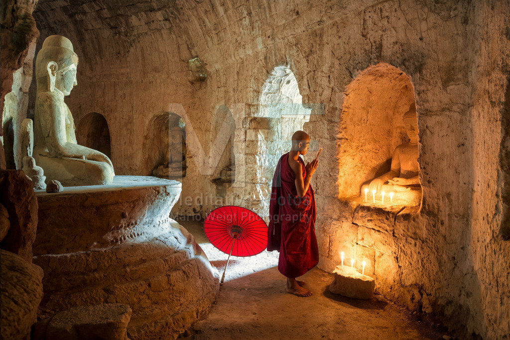 MW0117-7094 | Betender Mönch vor einer Buddha-Statue im Kerzenlicht - Realisiert mit Pictrs.com