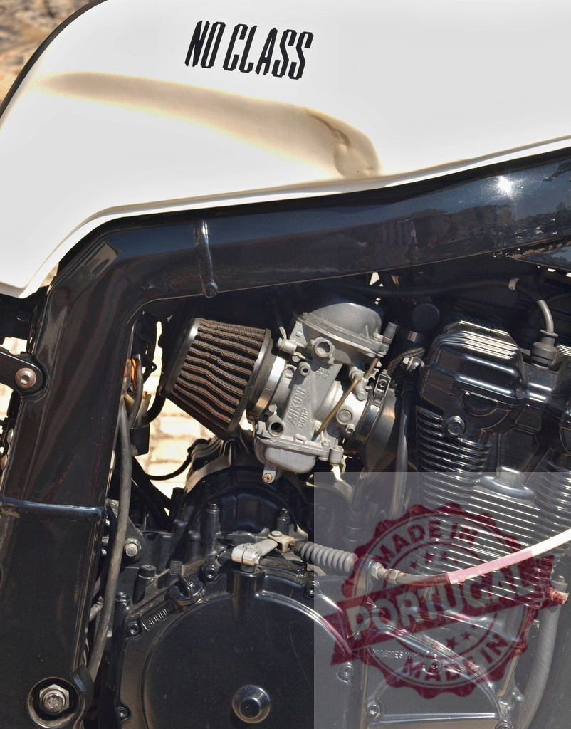 Custom motorcycle engine detail showing carburetor and fuel tank | Custom motorcycle engine with exposed carburetor, air filter, and NO CLASS text on fuel tank - Realisiert mit Pictrs.com