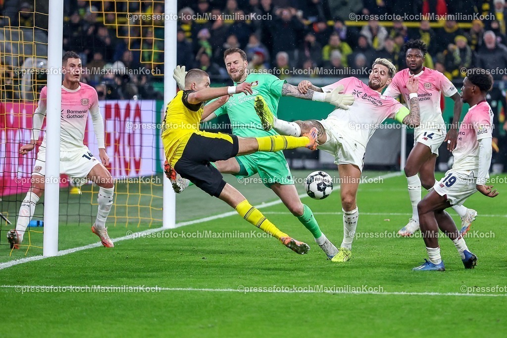 BVB02122501084 | 02.12.2025, Fußball, DFB-Pokal, Borussia Dortmund - Bayer 04 Leverkusen, Achtelfinale, Signal Iduna Park, Saison 2025 2026: Torwart Mark Flekken (Bayer04 #01) verteidigt gegen Waldemar Anton (BVB #03) zusammen mit Robert Andrich (Bayer04 #08) DFB regulations prohibit any use of photographs as image sequences and or quasi-video.
