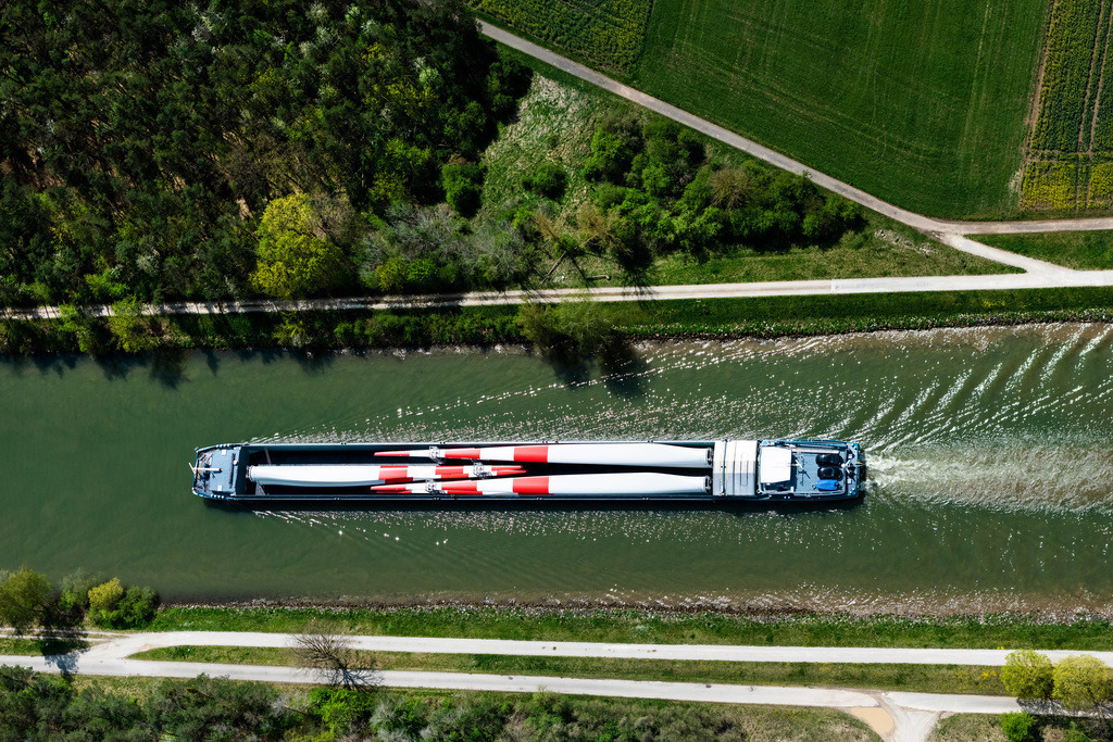 dr__0095813.jpg | BAMBERG 28.04.2022 Schiffe und Schleppverbände der Binnenschiffahrt in Fahrt auf der Wasserstraße des Flußverlaufes der Regnitz beladen mit großen Windrad Blättern in Bamberg im Bundesland Bayern, Deutschland. // Ships and barge trains inland waterway transport in driving on the waterway of the river of Regnitz beladen with grossen Windrad Blaettern in Bamberg in the state Bavaria, Germany. Foto: Daniel Reiter