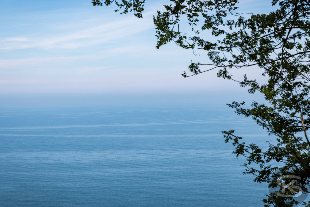 Ausblick über die Ostsee vom Nationalpark Jasmund  | Ausblick von den weißen Kreidefelsen im Nationalpark Jasmund der Insel Rügen über die Ostsee und umgeben von grünem Buchenwald. - Realisiert mit Pictrs.com