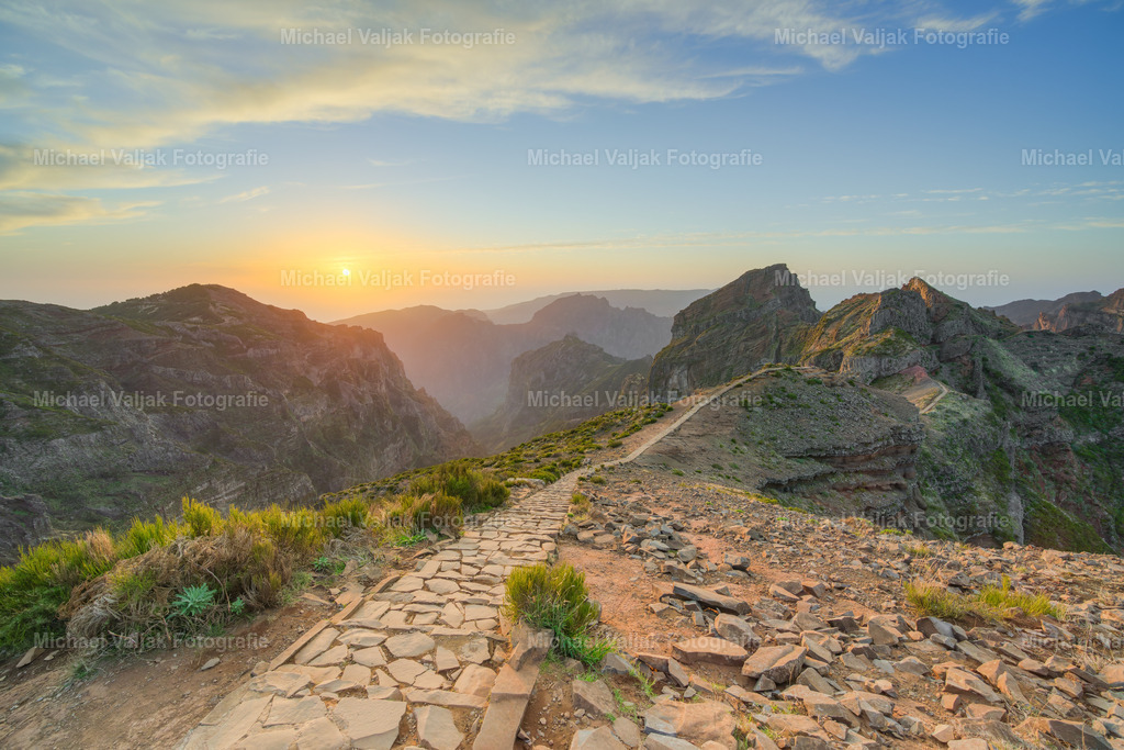 Auf dem Pico do Arieiro auf Madeira bei Sonnenuntergang | Der Pico do Arieiro, einer der höchsten Berge Madeiras, bietet nicht nur tagsüber spektakuläre Ausblicke über die zerklüftete Landschaft der Insel, sondern verwandelt sich bei Sonnenuntergang in ein wahres Naturwunder. Wenn die untergehende Sonne langsam hinter den Wolken verschwindet und die Landschaft in ein warmes Licht taucht, fühlt man sich wie in einer anderen Welt. - Realisiert mit Pictrs.com