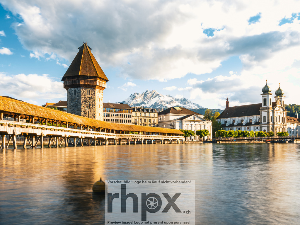Kapellbrücke und Wasserturm Luzern im Abendlicht | Die tief stehende Sonne bricht sternförmig hinter dem Wasserturm hervor und taucht die Kapellbrücke sowie die Altstadt von Luzern in warmes Abendlicht.  - Realisiert mit Pictrs.com