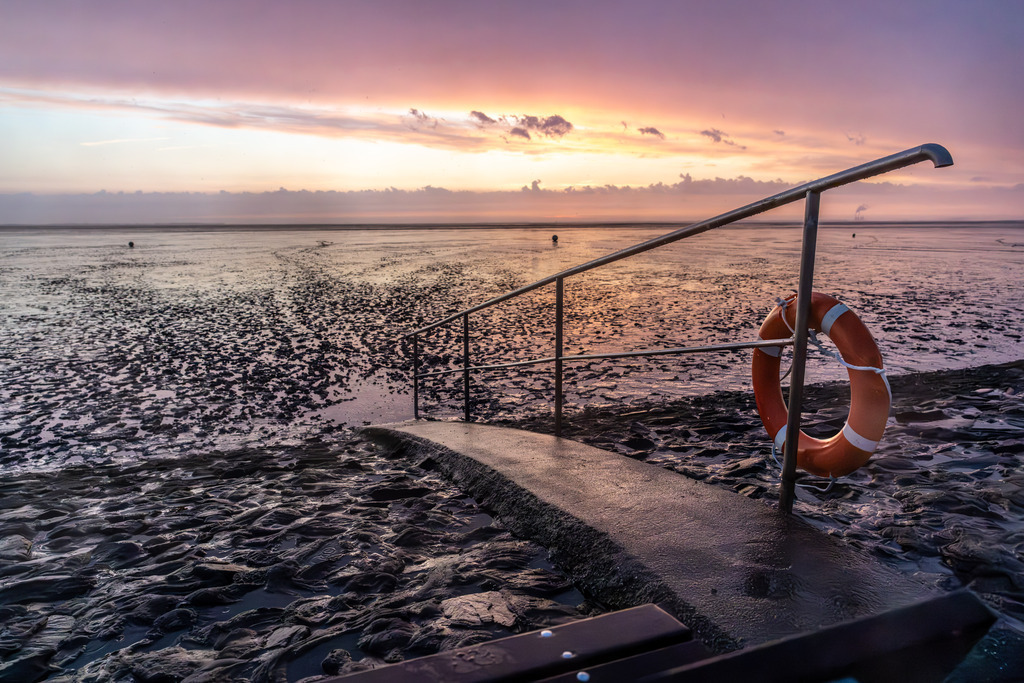 Sonnenuntergang am Wattenmeer | Starker Regen steht bevor, die ersten Tropfen erreichen den Boden. Doch die Sonne lässt es sich nicht nehmen, die Kulisse vorher in eine tolle Farbgebung zu tauchen.