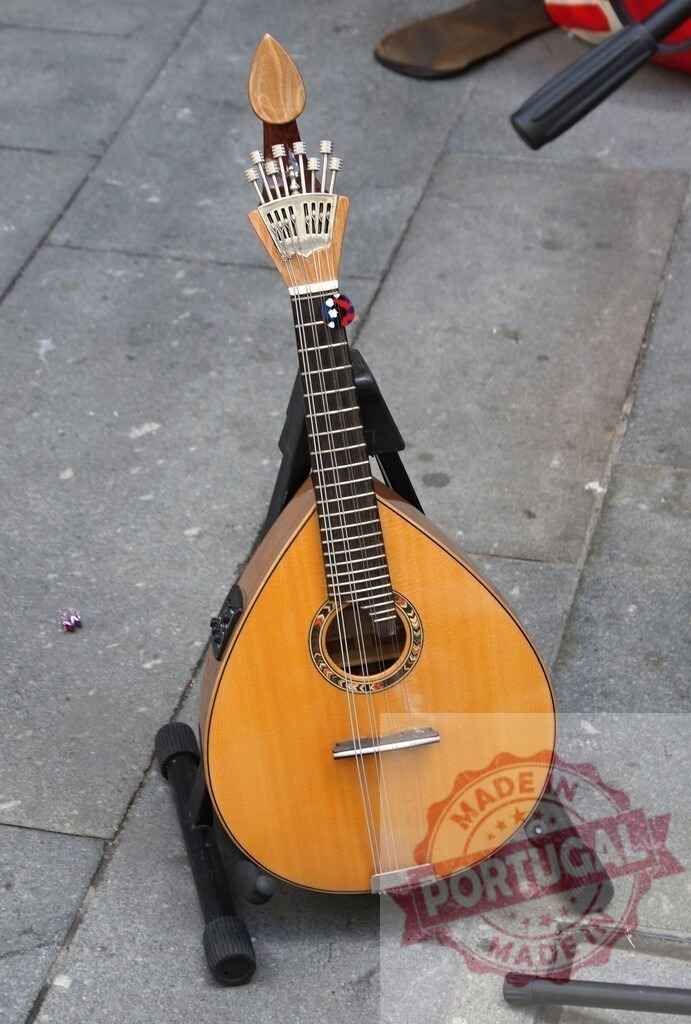 Portuguese guitar on stand for fado music | Portuguese guitar resting on a stand on the sidewalk, ready for fado performance - Realized with Pictrs.com