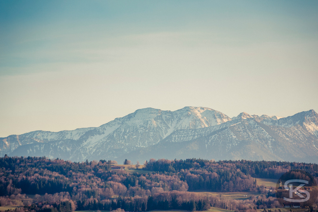 Neblige Voralpenlandschaft im Herbst - Bergpanorama Bayern | Atmosphärisches Panorama der nebelverhangenen Voralpenlandschaft im herbstlichen Licht. Sanfte Hügel, herbstliche Wälder und mystischer Dunst vereinen sich zu einer malerischen Szenerie in Süddeutschland mit Blick auf die Alpen. - Realisiert mit Pictrs.com