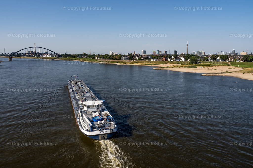 Blick auf den Rhein in Düsseldorf | Fahrendes Binnenschiff auf dem Rhein in Düsseldorf am Tag. - Realisiert mit Pictrs.com