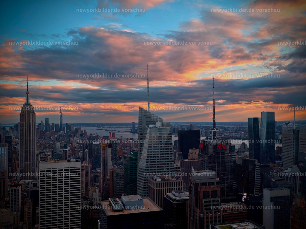 Magie über Manhattan – Sonnenuntergang vom Top of the Rock | Ein traumhafter Blick über Manhattan vom Top of the Rock – die Sonne senkt sich langsam hinter die Skyline und taucht die Stadt in ein warmes, sanftes Licht. Von hier oben eröffnet sich eine Perspektive, die die ganze Magie von New York einfängt: Wolkenkratzer, die sich wie Monumente in den Himmel recken, Straßen, die sich in der Ferne verlieren, und ein Horizont, der in Gold und Orange glüht. Dieses Foto ist mehr als eine Aussicht – es ist ein Gefühl von Freiheit, Weite und urbaner Schönheit. 