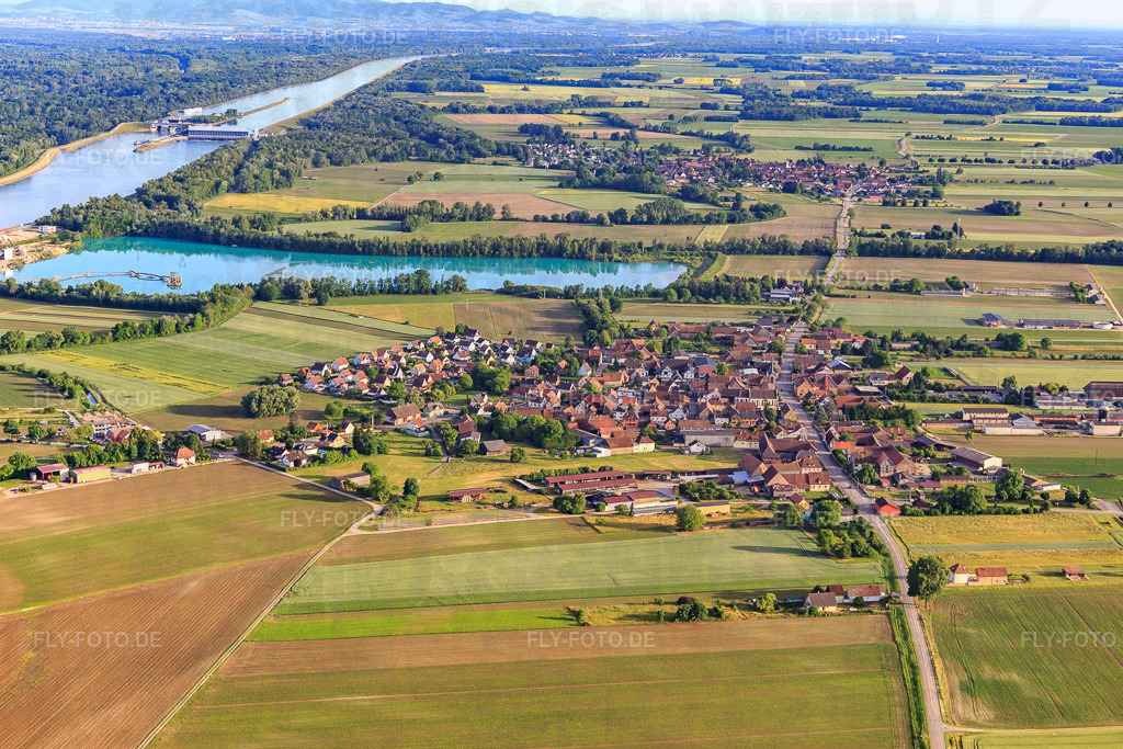 Dorfansicht aus Norden vor Baggersee/Kieswerk der Les Gravières Rhénanes SAS http://www.cc-rhin.fr/cgi-local/lei_fichedescriptive.pl?ID=261000333-!-GENRE=1900013-!-langue=1 | Luftbild: Dorfansicht aus Norden vor Baggersee/Kieswerk der Les Gravières Rhénanes SAS http://www.cc-rhin.fr/cgi-local/lei_fichedescriptive.pl?ID=261000333-!-GENRE=1900013-!-langue=1 in Friesenheim im Bundesland Bas-Rhin in Frankreich. Foto: IMG_147346.jpg vom 29.05.2025 durch Werner Riehm/FLY-FOTO.de - Realisiert mit Pictrs.com