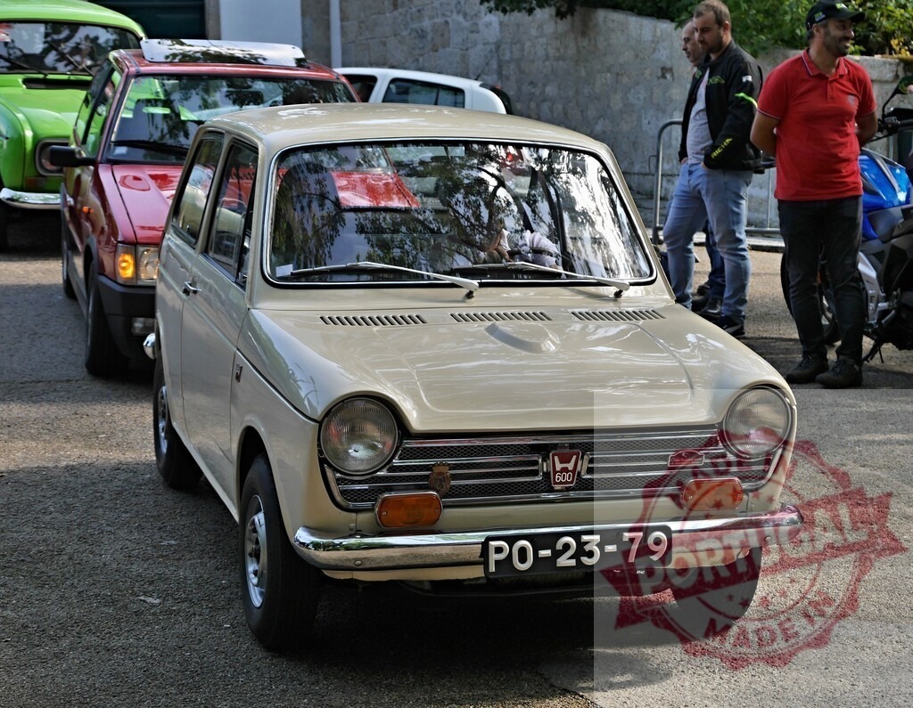 Honda N600 vintage kei car at classic automobile event | Classic beige Honda N600 parked on asphalt at an outdoor car show - Realized with Pictrs.com