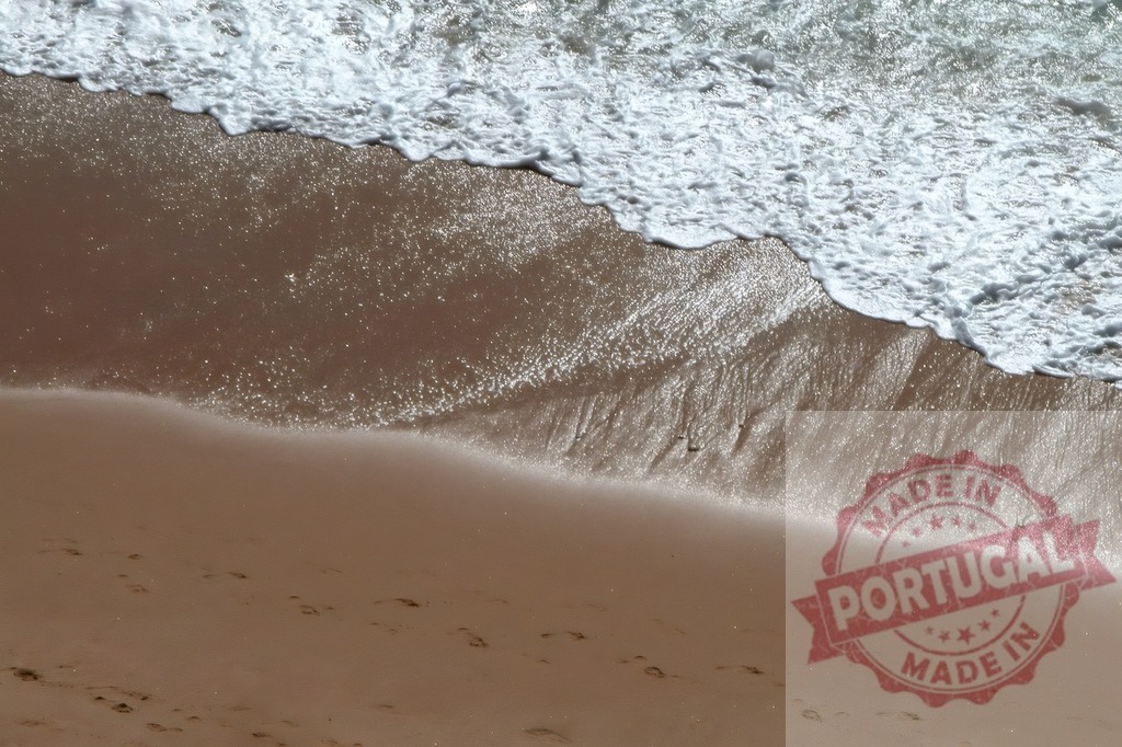 Ocean waves washing shore creating foam on sand | Waves washing onto a sandy beach with foaming water and subtle footprints - Realisiert mit Pictrs.com