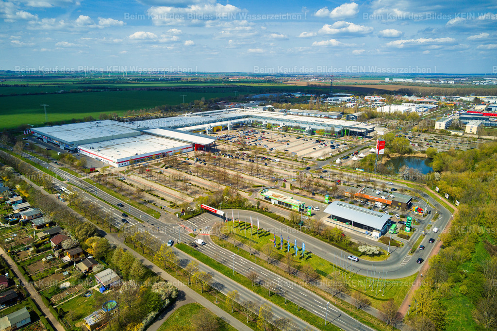 Florapark-Magdeburg-0032 | Blick aus der Vogelperspektive auf den Florapark im Norden Magdeburgs. Das Einkaufszentrum prägt mit seiner weitläufigen Bebauung und den angrenzenden Verkehrsflächen einen wichtigen Bereich des nördlichen Stadtteils. Der Florapark wurde 1993 eröffnet und gehörte damit zu den ersten großen Einkaufszentren, die nach der Wiedervereinigung in Magdeburg entstanden. Mit seiner Eröffnung veränderte sich auch die Einkaufslandschaft im Norden der Stadt.Heute verbindet der Florapark zahlreiche Geschäfte, Dienstleistungen und gastronomische Angebote unter einem Dach und ist für viele Magdeburger ein vertrauter Anlaufpunkt im Alltag.Aus der niedrigen Vogelperspektive wirkt das Gebäude deutlich unmittelbarer als bei einer hohen Gesamtansicht. Die Architektur, Zufahrten und das Umfeld werden zu einem typischen Stadtbild des Magdeburger Nordens.Kein historisches Wahrzeichen – sondern ein Stück Magdeburger Alltag und Stadtentwicklung nach 1990. - Realisiert mit Pictrs.com