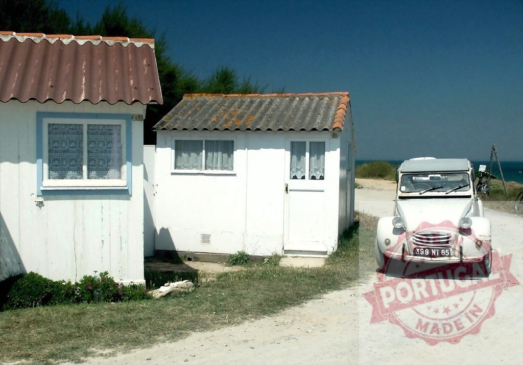 White Citroën 2CV parked near beach houses in Gouville-sur-Mer, Normandy, France | Classic white Citroën 2CV car parked on a dirt road near typical white beach houses in Gouville-sur-Mer, Normandy, France, enjoying summer holidays - Realisiert mit Pictrs.com