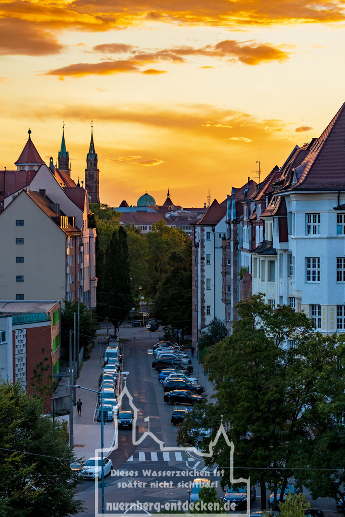Roter Sonnenuntergang über Nürnberg | Der Blick durch die Theodorstraße in Nürnberg, mit den vielen gut erhaltenen Jugendstil-Mietshäuser, in Richtung der Altstadt von Nürnberg. Man erkennt die Zwillingstürme der Lorenzkirche und auch die Kuppel der Elisabethkirche. - Realisiert mit Pictrs.com