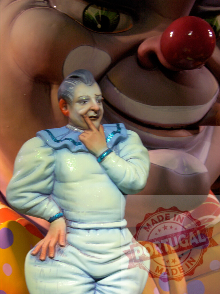 Colorful festival sculpture depicting clown figure celebrating carnival. Fallas Fiestas Communidad Valenciana | Colorful sculpture of a smiling clown figure with a large background face - Realized with Pictrs.com