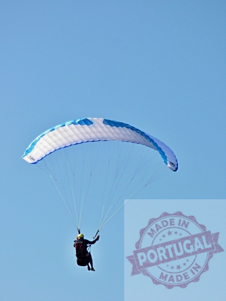 Person paragliding in blue sky experiencing freedom | Person paragliding under a blue sky, enjoying the thrill of flight - Realisiert mit Pictrs.com
