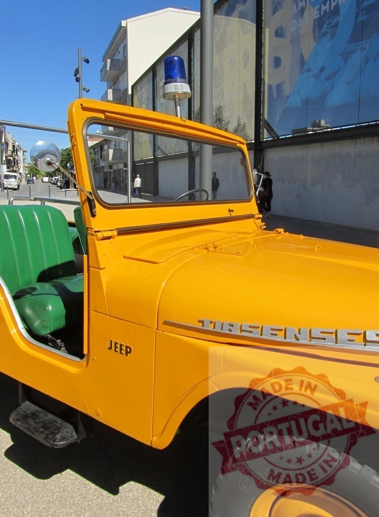 Yellow vintage Jeep parked on city street | Yellow vintage Jeep with green seats and blue siren light parked on a bright day - Realisiert mit Pictrs.com