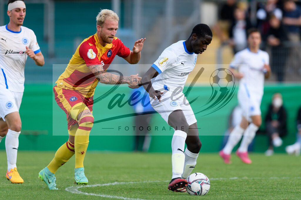 LOTKSC20210809_188 | Fussball, Herren: Philipp Hofmann (Karlsruher SC) und Komlan Fionouke (Sportfreunde Lotte) im Zweikampf beim Spiel der 1. Runde im DFB-Pokal zwischen SF Lotte und Karlsruher SC im Stadion am Lotter Kreuz am 09.08.2021 in Lotte, Deutschland.DFB / DFL REGULATIONS PROHIBIT ANY USE OF PHOTOGRAPHS AS IMAGE SEQUENCES AND/OR QUASI-VIDEO. - Realisiert mit Pictrs.com