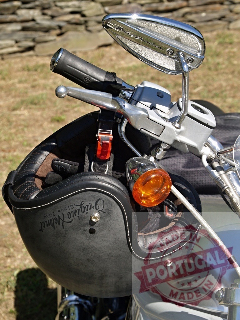 Black motorcycle helmet hanging from the handlebar of a Harley-Davidson | Motorcycle helmet hanging from the handlebar of a Harley-Davidson, with gloves inside - Realisiert mit Pictrs.com