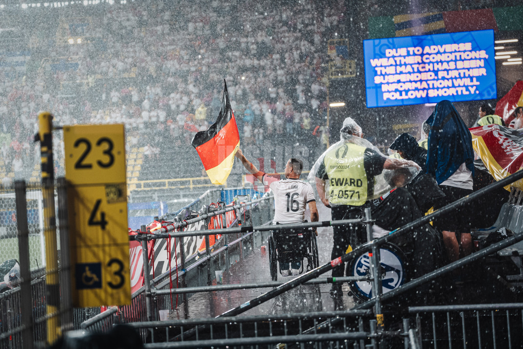 Fußball | Herren | UEFA-Fußball-Europameisterschaft 2024 | Achtelfinale | Deutschland vs. Dänemark | 29.06.2024 | Ein Fan schwenkt die Fahne im Regen