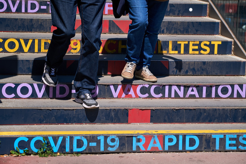 Menschen auf der Treppe mit Aufschrift Covid-Schnelltest | Wien, Austria - June 02, 2021: Maßnahmen zur Einschränkung von COVID-19; Menschen auf der Treppe mit Aufschrift Covid-Schnelltest. - Realisiert mit Pictrs.com