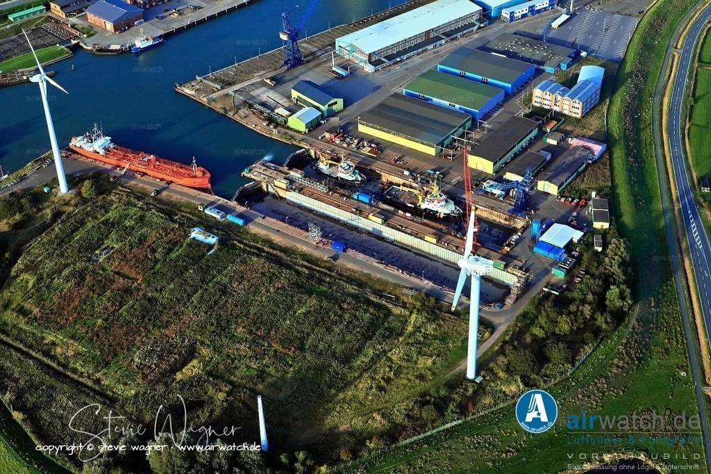 Luftbild Husum, Aussenhafen, Husum-Dock+Reparatur | Die Husumer Schiffswerft, offiziell Husumer Dock und Reparatur GmbH & Co. KG (HDR), ist eine deutsche Werft in Husum, Schleswig-Holstein. Sie wurde 1919 gegründet und hat sich auf den Neubau und die Reparatur von kleinen bis mittleren Schiffen spezialisiert, insbesondere Fischkutter, Forschungs- und Spezialschiffe. Die Werft besitzt langjährige Erfahrung in der Holzschiffbauerei und hat im Laufe der Jahre auch Stahl- und Aluminiumkonstruktionen übernommen.