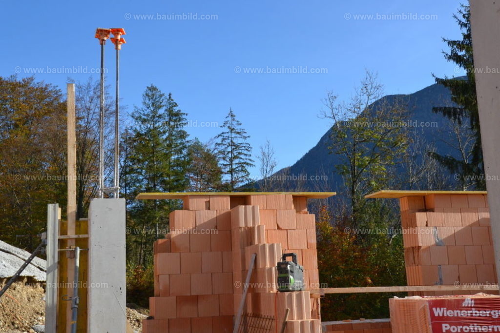 Ziegelmauerwerk und Betonsäule | Ziegelmauerwerk aus gebrannten Hochlochziegeln und Betonsäule mit Anschlussbewehrung, Hintergrund blauer Himmel
