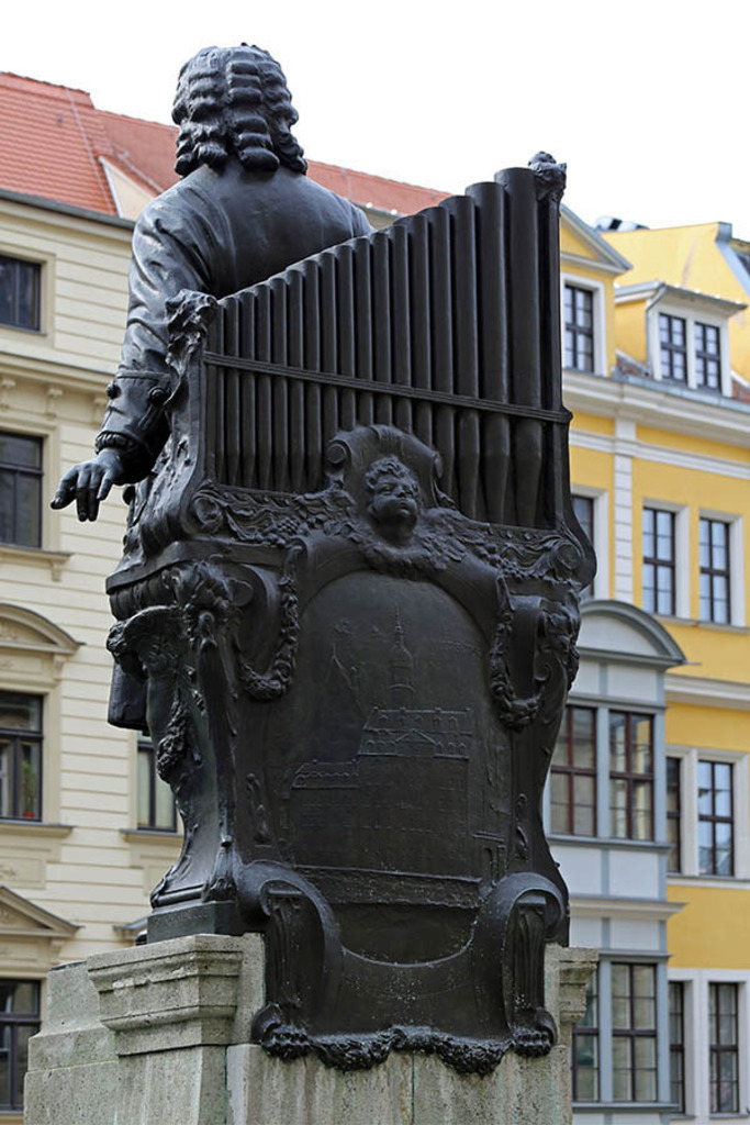 Bildlexikon Leipzig - Bach Denkmal - Rückseite mit Relief der Thomasschule | Das Team hinter BILDLEXIKON LEIPZIG bündelt historische wie aktuelle Informationen über die Stadt Leipzig in Text und Bild auf einer Plattform und stellt diese der interessierten Öffentlichkeit zur Verfügung.